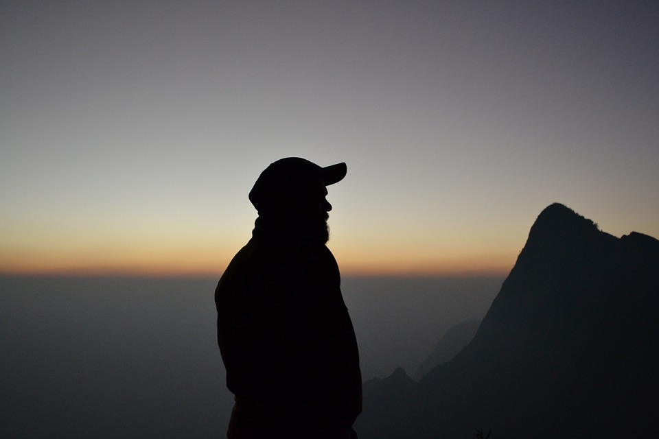 silhouette d'un homme avec une casquette au coucher de soleil